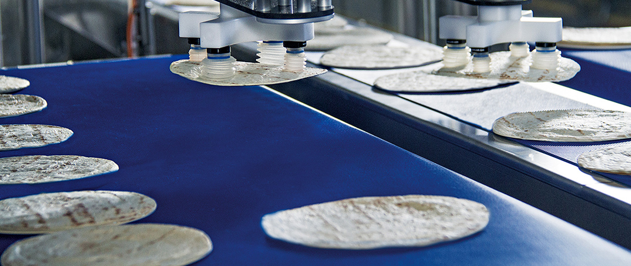 Delta robots pick unpacked tortillas and place them on a conveyor belt.